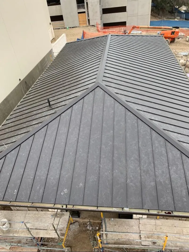 Commercial metal roof construction with crane equipment in Lakeville